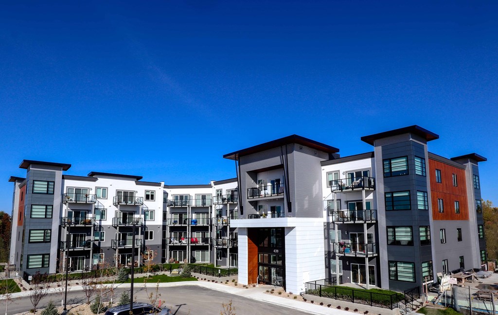 an exterior view of an apartment complex with a blue sky