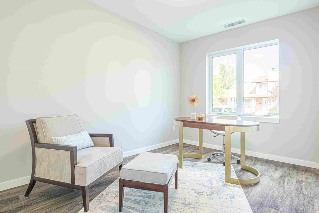 a living room with a chair and a table and a window