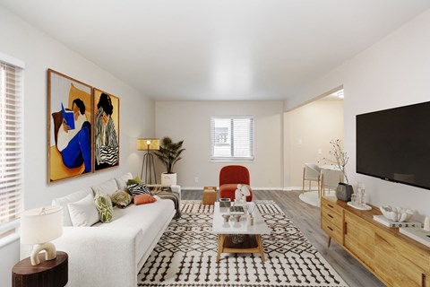 A living room with a white couch, a coffee table, and a painting on the wall.