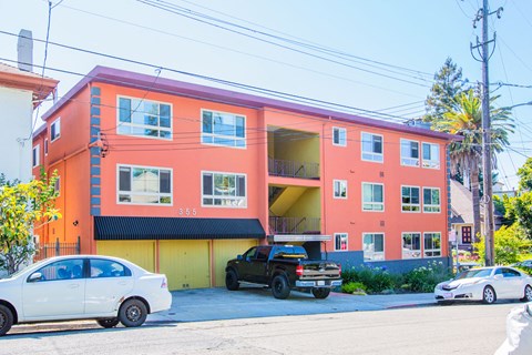 A bright orange building with a white car parked in front.