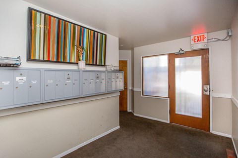 A hallway with a red exit sign above the door.