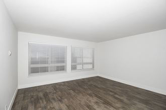 an empty room with white walls and wood floors and a window