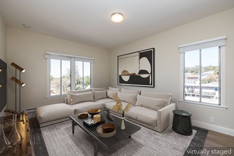 A living room with a couch, coffee table, and a large mirror on the wall.