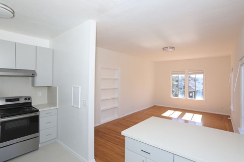 A kitchen with white cabinets and a stove top oven.