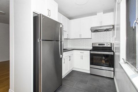 A modern kitchen with a stainless steel refrigerator and oven.