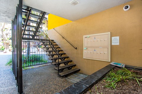 A staircase with a yellow triangle on the wall.