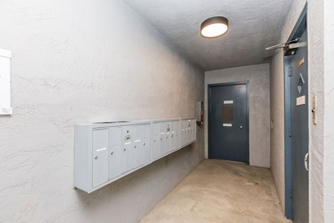 A hallway with a blue door and white walls.
