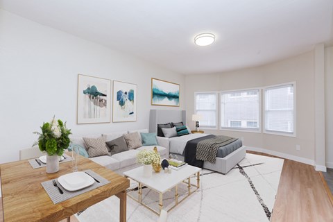 A modern living room with a wooden dining table and a white sofa.