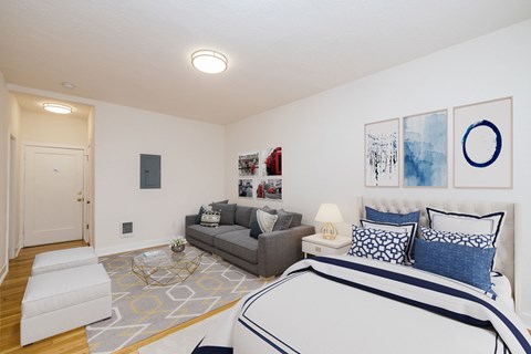 A bedroom with a large bed and a grey couch.