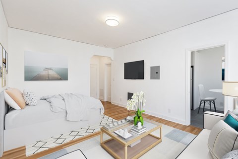 A modern living room with a large bed and a painting on the wall.
