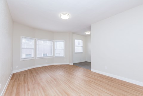 A room with wooden flooring and white walls.