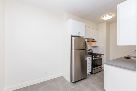 A kitchen with a stainless steel refrigerator, stove, and oven.