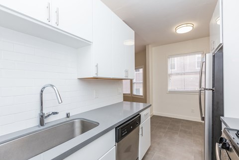 A kitchen with a sink, stove, and refrigerator.
