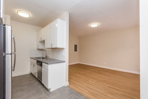 A kitchen with white cabinets and a refrigerator.