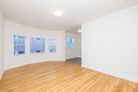 A room with wooden flooring and white walls.