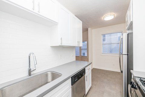 A kitchen with white cabinets and stainless steel appliances.