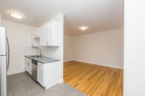 A kitchen with white cabinets and a refrigerator.
