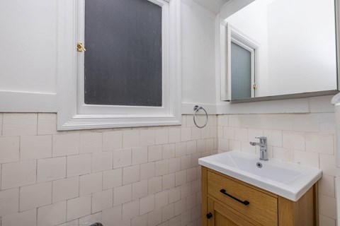 A bathroom with a white sink and a mirror.