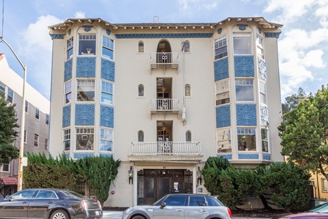 A white building with blue trim and a balcony.
