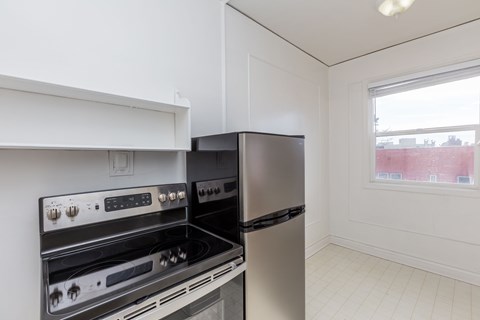 A kitchen with a stove top oven and a refrigerator.