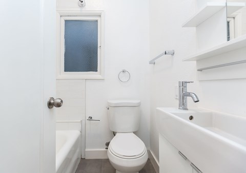 A white bathroom with a toilet, sink, and bathtub.