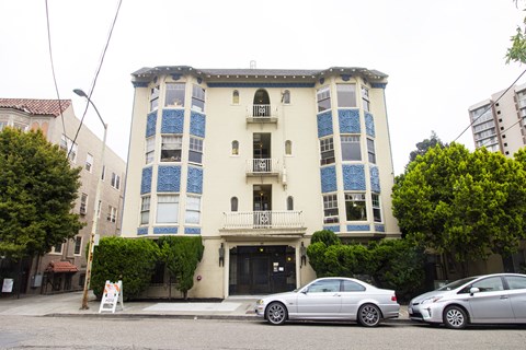 Two cars parked in front of a building with blue and white trim.