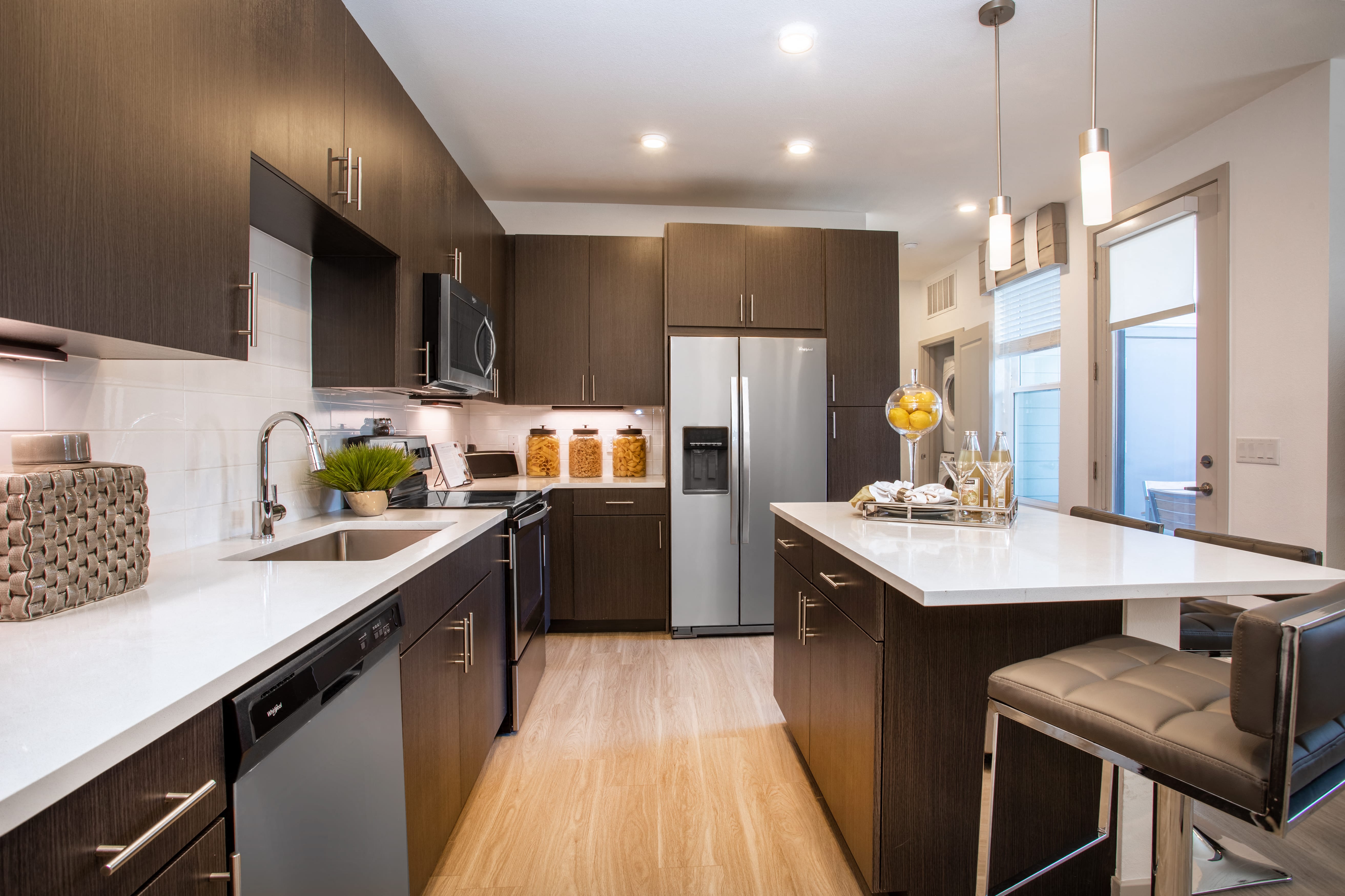 a kitchen with wooden cabinets and white counter tops and stainless steel appliances