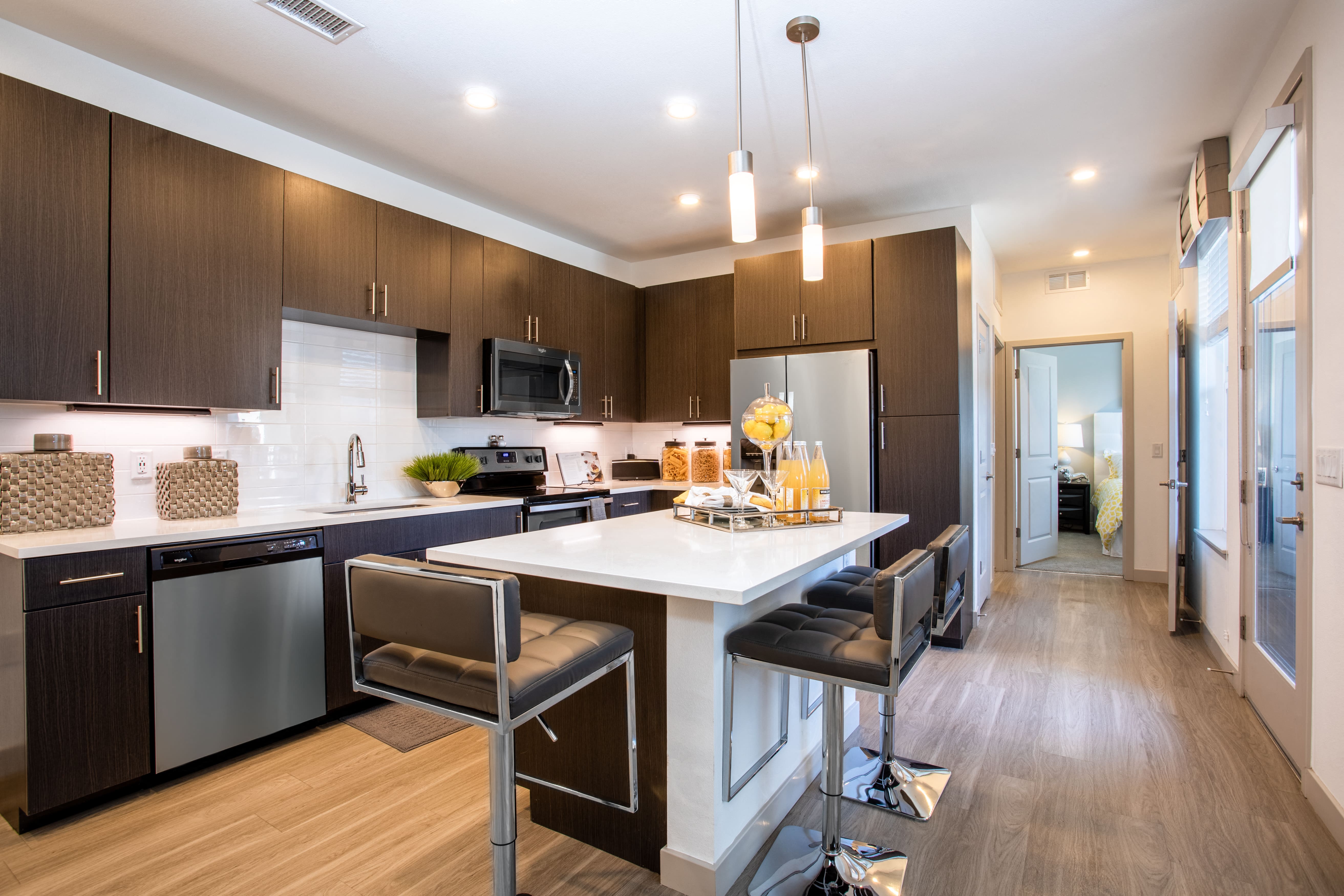 a kitchen with a large island with three chairs