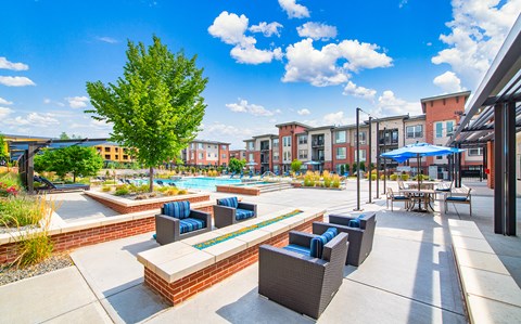 an outdoor patio with lounge chairs and a pool at the residences at town center apartments