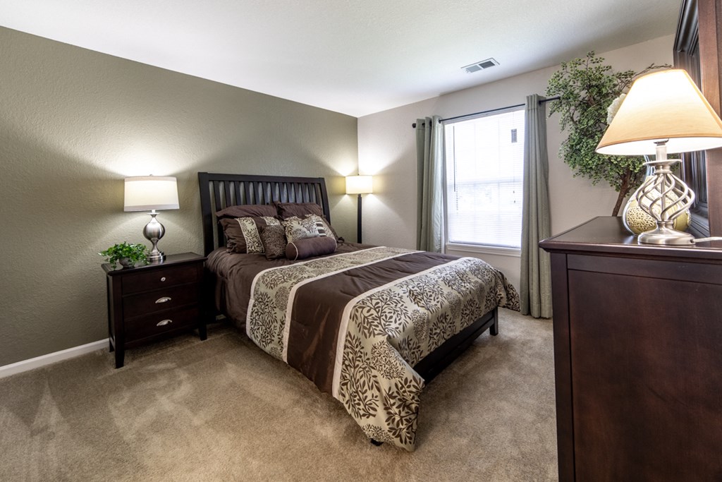 a bedroom with a bed and a dresser and a window