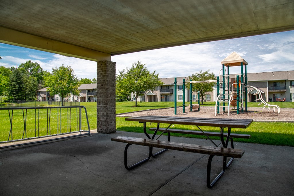 a picnic table and playground equipment in a park