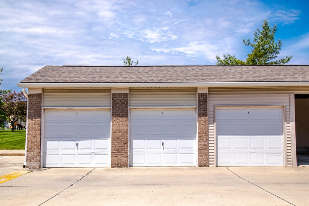 the front of a garage with three white garage doors