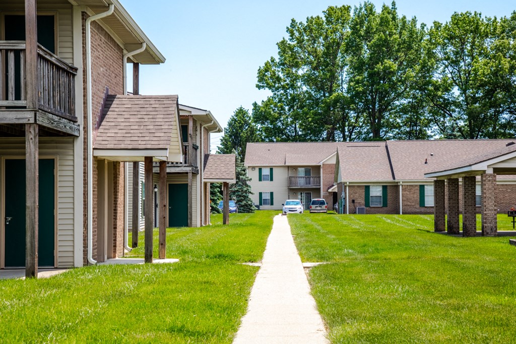 a row of houses with green grass and a sidewalk