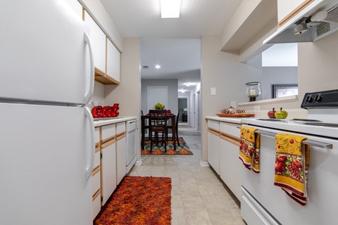 a kitchen with white cabinets and white appliances and a white refrigerator