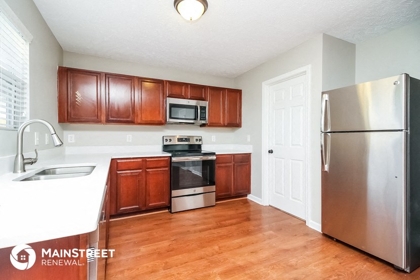 a kitchen with wooden cabinets and stainless steel appliances