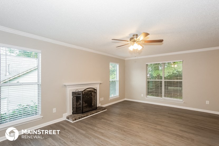 a living room with a fireplace and a ceiling fan
