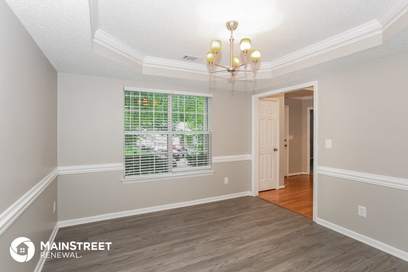 the living room and dining room of a house with a large window