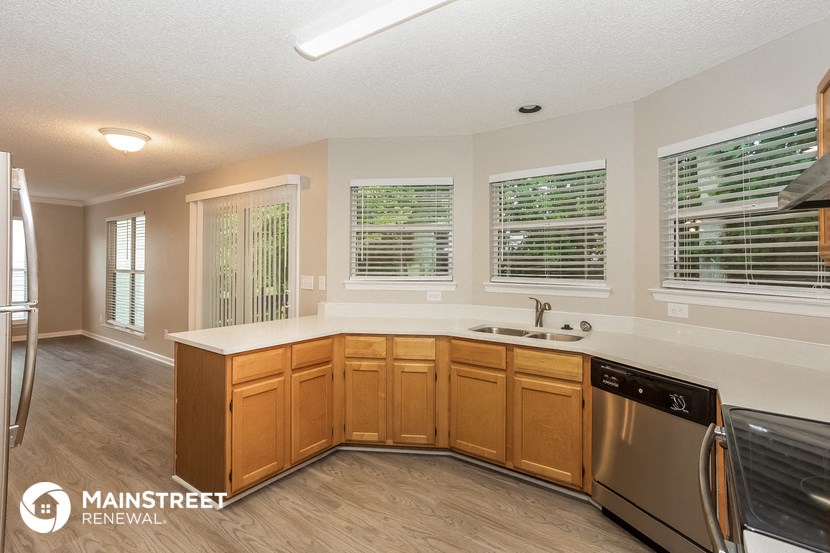 the kitchen has a large island and stainless steel appliances