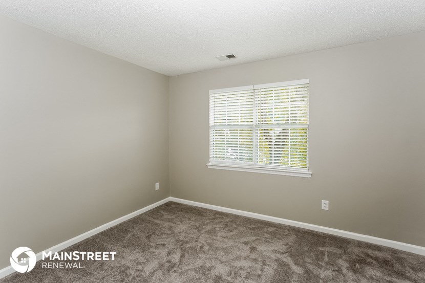 the upstairs bedroom with carpet and a window