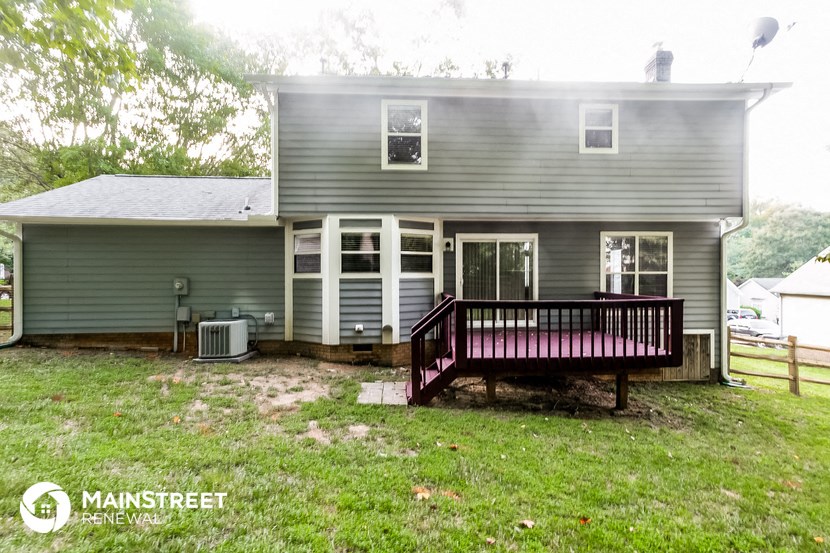 the back of a house with a porch and a deck