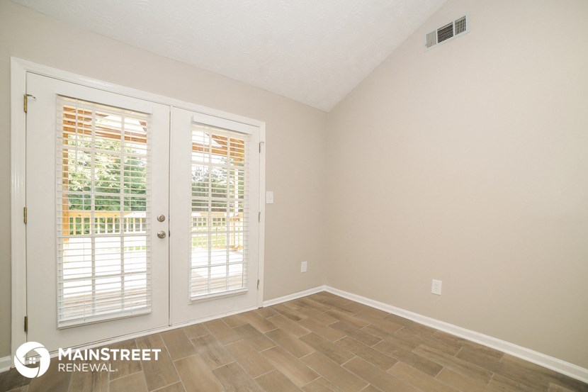 the living room of a home with white doors and a tiled floor