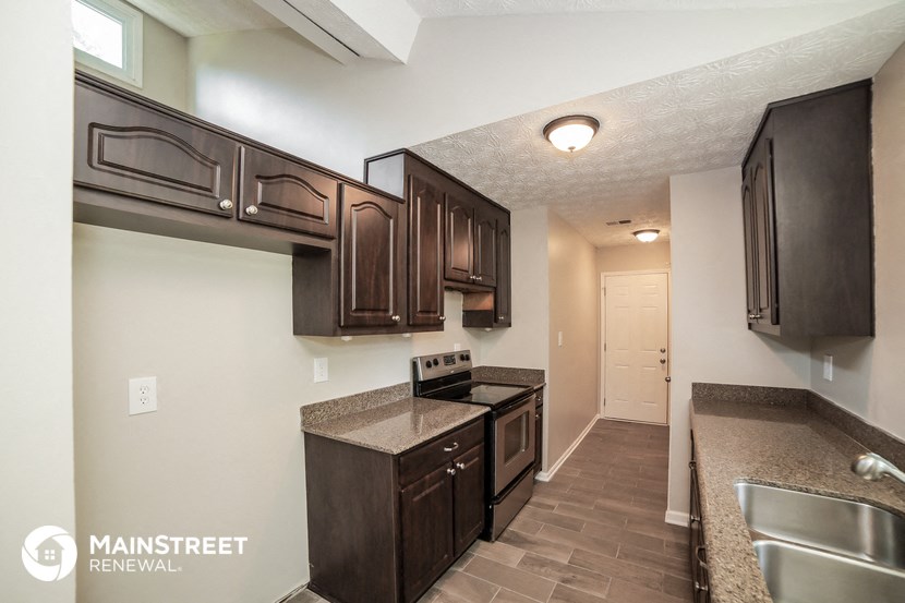 a kitchen with dark wood cabinets and granite counter tops and a sink
