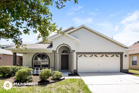 a white house with a garage door and a driveway