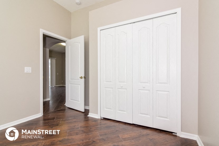 a master bedroom with two closets and a door to a hallway with a hallway
