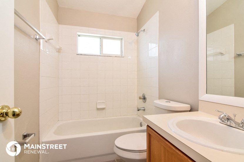 a bathroom with a tub sink and toilet and a mirror