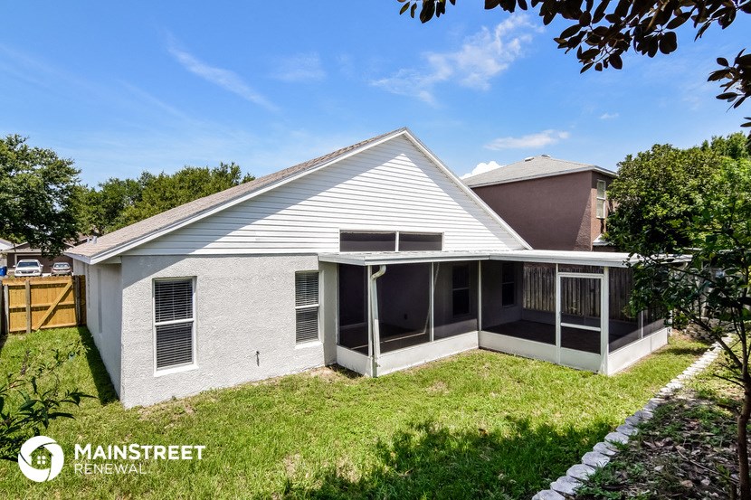 a small white house with a porch and a lawn