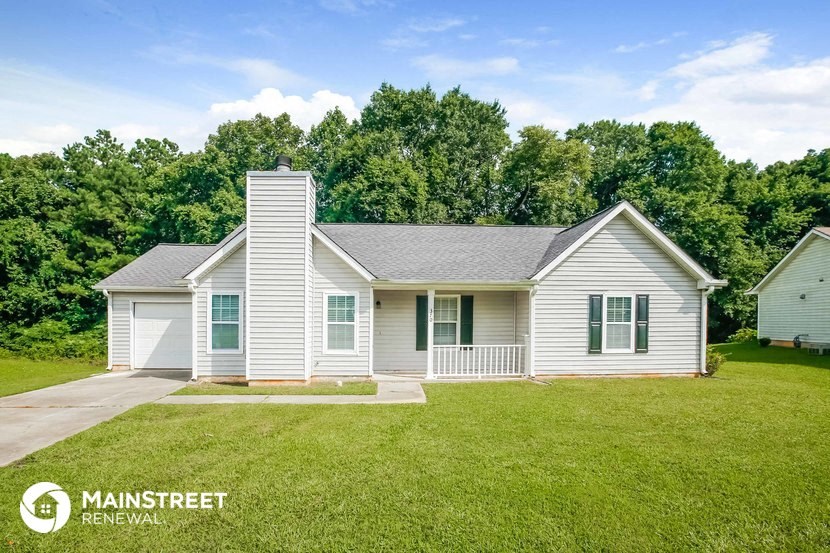 a white house with green shutters and a grassy yard