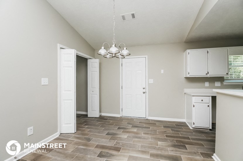 a kitchen with white cabinets and a tile floor
