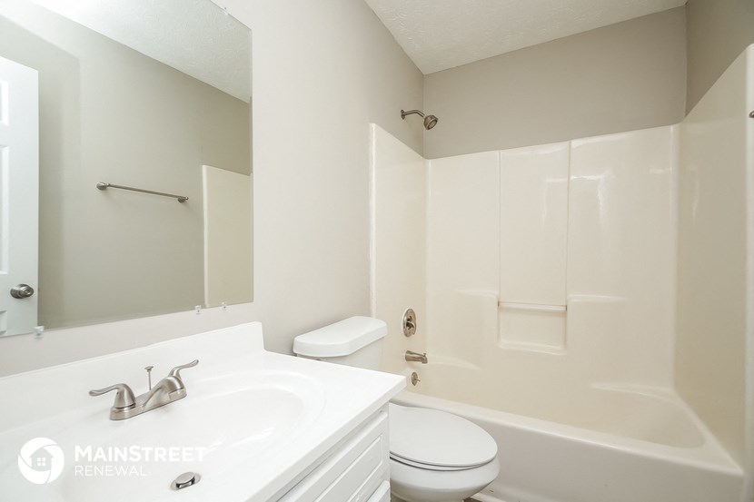 a bathroom with a sink toilet and tub and a mirror