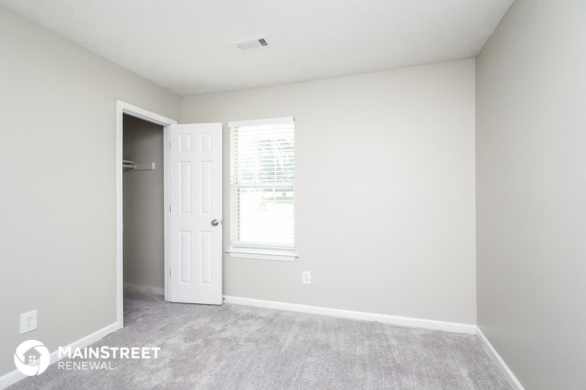 a bedroom with a closet and a door and a window